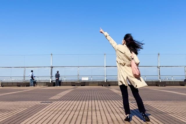 空を指さす女性